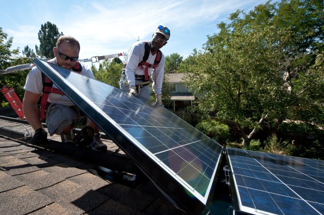 two men installing solar panels on a roof