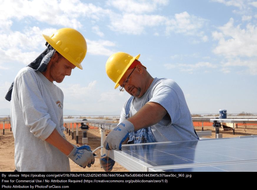 Men installing ground-mounted solar panels