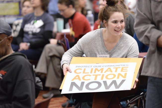 Young woman holding sign that says Climate Action Now